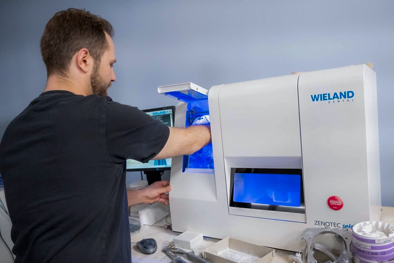Prothésiste travaillant sur une unité d’usinage au laboratoire Orviz